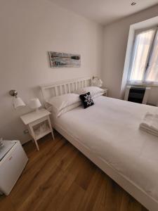 a bedroom with a large white bed and a window at Affittacamere Il Timone in Corniglia