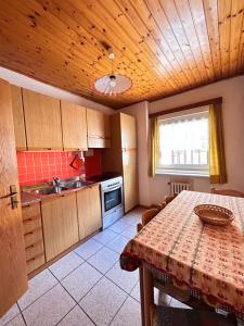 a kitchen with a table and a sink and a counter at Apartment Nido in Selva di Val Gardena