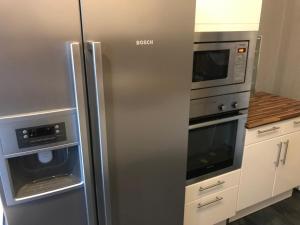 卡塞爾的住宿－KASSEL @ YSENBURGSTRASSE，厨房配有不锈钢冰箱和微波炉。