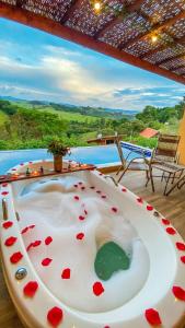 a bath tub with hearts on it in front of a pool at Chalé Arara super Luxo in Cunha