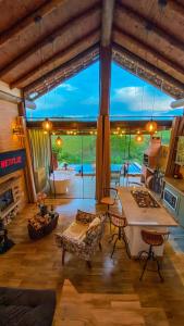 uma sala de estar com uma grande janela e uma mesa em Chalé Arara super Luxo em Cunha