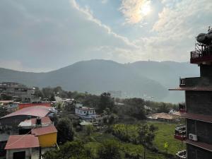 vistas a una ciudad con montañas en el fondo en Hostel The Good Earth Pvt. Ltd. en Pokhara