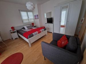 MiesにあるBnB "Les Coquelicots"のベッドルーム1室(ベッド1台、ソファ、椅子付)