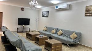 a living room with a couch and a flat screen tv at Sunrise Farm استراحة مطلع الشمس in Hatta