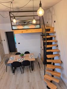 Cette chambre dispose d'une table à manger et d'une mezzanine. dans l'établissement Apartament z antresolą, à Mikoszewo