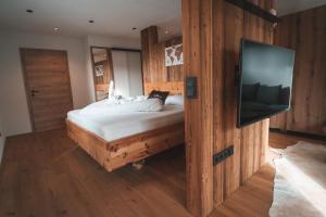 a bedroom with a bed and a flat screen tv at Landgasthof Wöhrer in Aigen im Ennstal