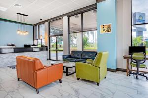 eine Lobby mit Stühlen, einem Sofa und einem Tisch in der Unterkunft Days Inn by Wyndham N Orlando/Casselberry in Orlando