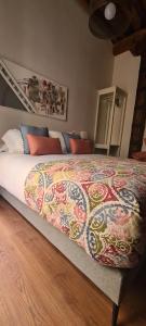 una camera da letto con un grande letto con una coperta colorata di Apartamento Viña P. Málaga Centro a Málaga