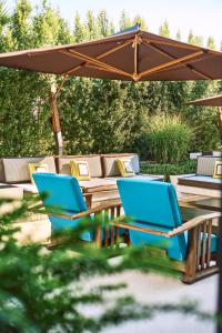 two blue chairs and a table under an umbrella at Savoy Hotel & Spa in Paestum