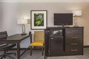 a hotel room with a desk and a flat screen tv at La Quinta by Wyndham Las Vegas Summerlin Tech in Las Vegas +35 photos