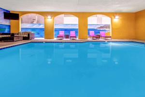 - une grande piscine dans une chambre d'hôtel dotée de chaises roses dans l'établissement La Quinta by Wyndham Anaheim, à Anaheim