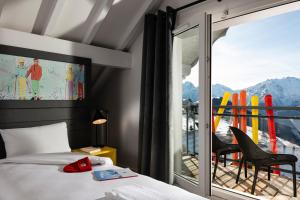a bedroom with a bed and a balcony with a view at PopAlp in L'Alpe-d'Huez