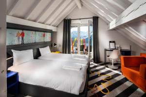 ein Hotelzimmer mit einem Bett und einem Stuhl in der Unterkunft PopAlp in L'Alpe-d'Huez
