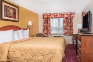 a hotel room with a bed and a television at Travelodge by Wyndham Klamath Falls in Klamath Falls