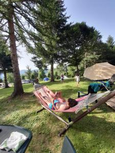 kobieta leżąca w hamaku w parku w obiekcie Tente aménagée 4pp w mieście Camurac +5 zdjęć