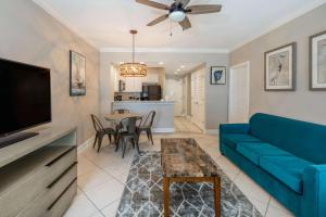 a living room with a blue couch and a table at Palm Beach Resort Orange Beach a Ramada by Wyndham in Orange Beach