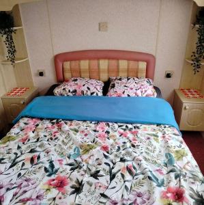 a bedroom with a bed with a floral bedspread at domek holenderski in Kołczewo