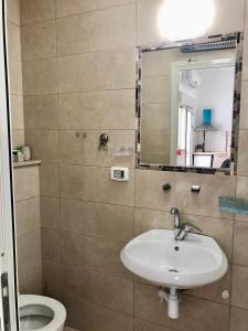 uma casa de banho com um lavatório, um WC e um espelho. em Bat Galim - by the sea em Haifa