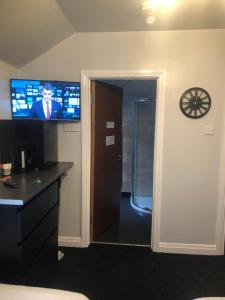 a room with a television and a door with a bathroom at Citi North in Belfast