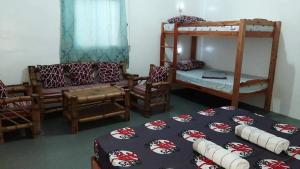 een kamer met 2 stapelbedden en een bank bij A&C Aquino's Guesthouse & Motorbike Rental - Moalboal in Moalboal