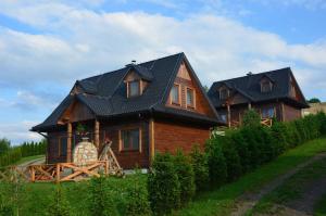 a large wooden house with a black roof at Słoneczna Kraina 1 in Wołkowyja