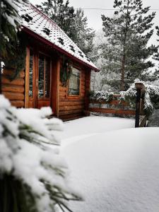 Cabaña de madera con nieve en el suelo en Nice House, en Maidan Village