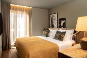 um quarto de hotel com uma cama e uma janela em Fontinha Porto, Trademark Collection by Wyndham no Porto