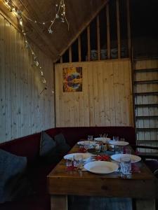 une table en bois avec des assiettes et des verres dans l'établissement Nice House, à Maidan Village