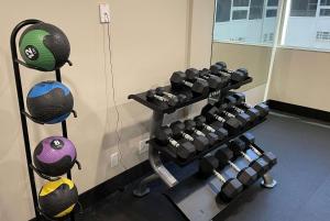 a gym with several rows of dumbbells on a wall at La Quinta Inn & Suites by Wyndham Indianapolis Downtown in Indianapolis