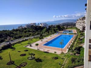 Blick auf einen Pool in einem Park mit Meerblick in der Unterkunft L'appartement Bella Vista - Vue panoramique sur la Méditerranée WIFI in Cabo Negro