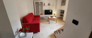 a living room with a red chair and a television at Residenza L'Archetto in Corona