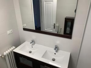 uma casa de banho com um lavatório branco e um espelho. em Villa Aurora em La Bañeza