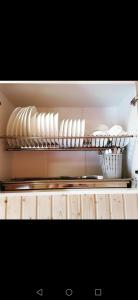 une cuisine avec des assiettes et des bols sur une étagère dans l'établissement Nice House, à Maidan Village