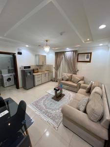 a living room with two couches and a kitchen at غايا للشقق المخدومة in Tabuk