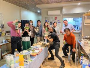 a group of people posing for a picture in a kitchen at HOSTEL PAQ tokushima in Tokushima