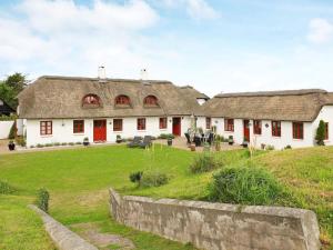 Casa blanca grande con puertas rojas y patio en 12 person holiday home in Blokhus, en Blokhus