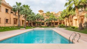 a swimming pool in a courtyard with palm trees at Casa Hermana in Los Alcázares
