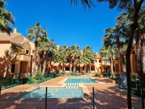 a villa with a swimming pool and palm trees at Casa Hermana in Los Alcázares