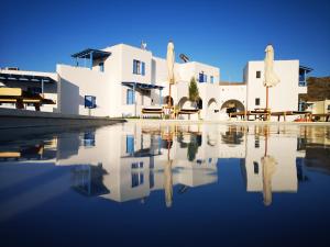 a house with a reflection in the water at Amodari studios on the beach in Plaka