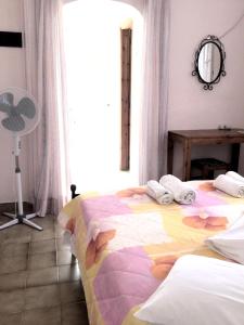 a bedroom with a bed with a colorful blanket on it at ARISTIDIS Studios in Lefkimmi