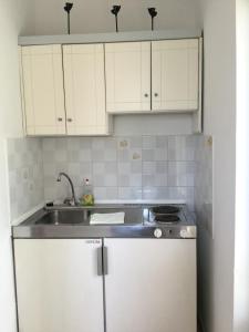 a kitchen with white cabinets and a sink at ARISTIDIS Studios in Lefkimmi