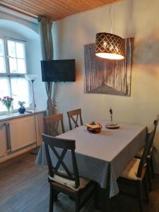 une salle à manger avec une table, des chaises et une télévision dans l'établissement Rüstzeitenheim Sonnenschein, à Saalburg