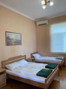 a room with two beds in a room with a window at Karina in Gagra