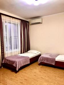 two beds in a room with a window at Karina in Gagra