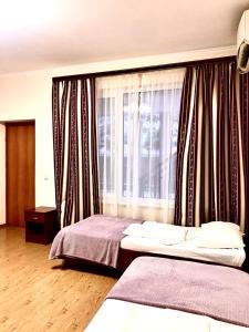a bedroom with two beds and a window at Karina in Gagra