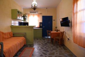 Cet appartement comprend une chambre avec un lit et une table ainsi qu'une cuisine. dans l'établissement Elia Studios Amorgos near the sea, à Aegiali