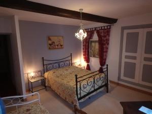 a bedroom with a bed and a chandelier at La Mare aux 3 Diables in Fresney-le-Vieux