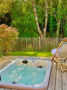 a hot tub sitting on a deck with a chair at Chambres avec Jacuzzi privatif - Kassiopée Bed & Spa in Albi