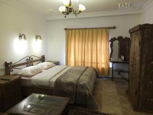 a bedroom with a bed and a table and a window at Anatolia cave hotel Pension in Goreme