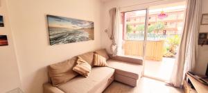 een woonkamer met een bank en een raam bij Caleta Relax - Apartamento Fuerteventura Apartment in La Oliva